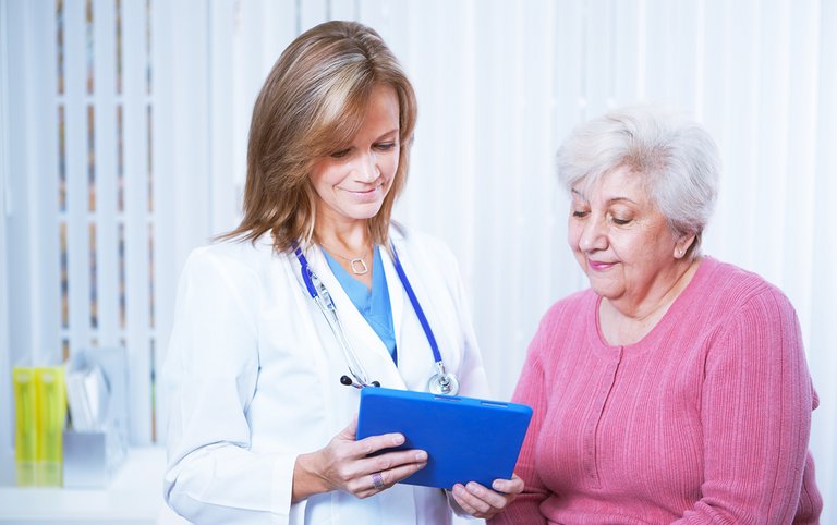 Médica e paciente olhando para um tablet