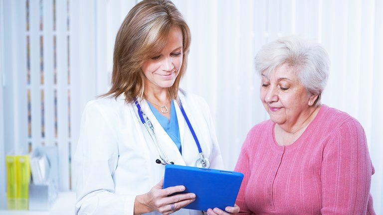 Médica e paciente olhando para um tablet