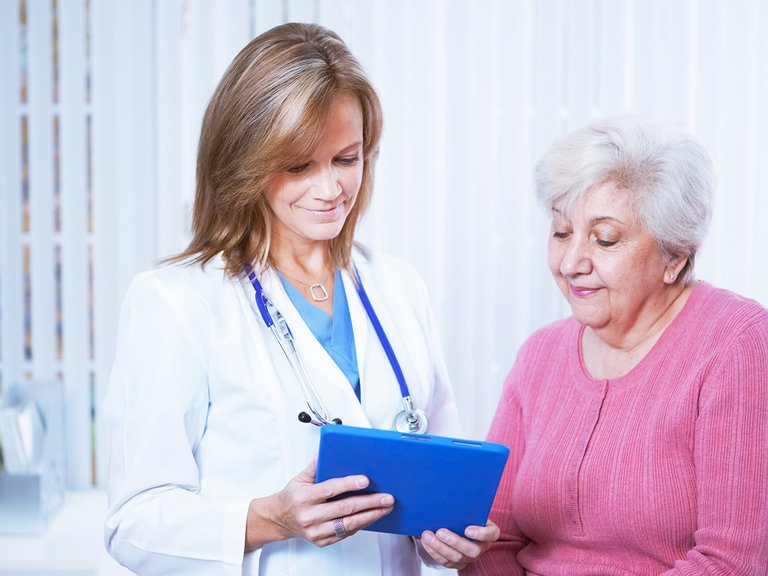 Médica e paciente olhando para um tablet