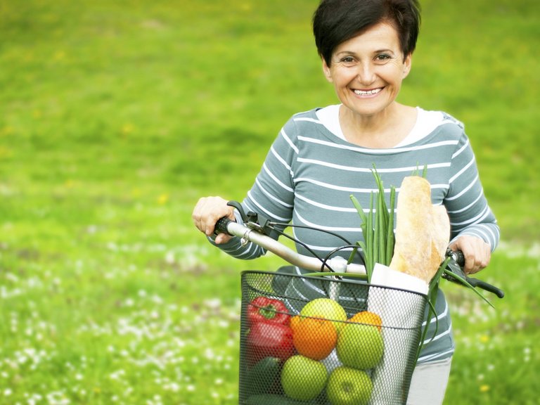 Woman on a bike with healthy food in the basket