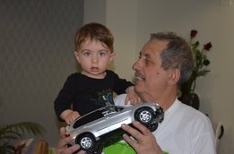 [Translate to Brasil:] Neculai Grigoraș playing with his grandson